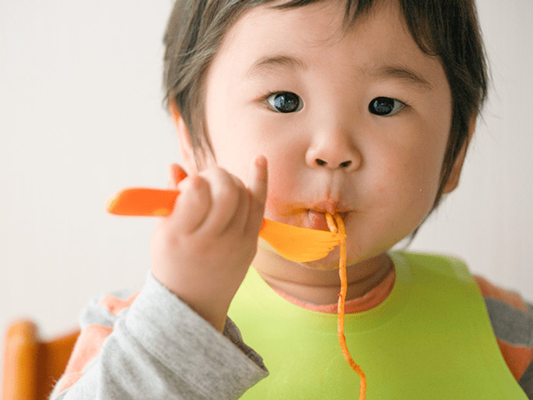 Why should mothers give their baby organic solids in the first years of life?